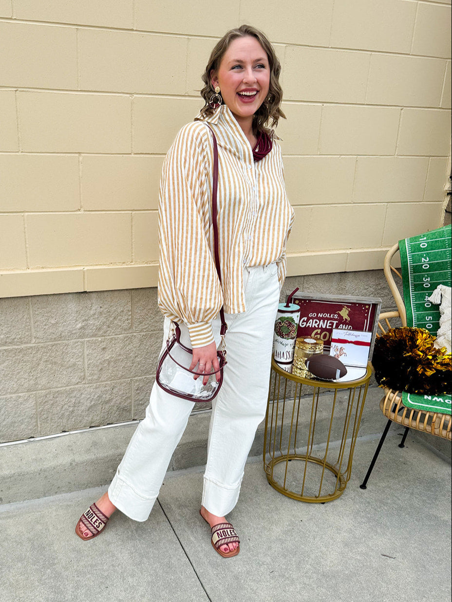 Clear crossbody stadium bag with garnet straps and gold hardware, perfect for stylish game day looks.