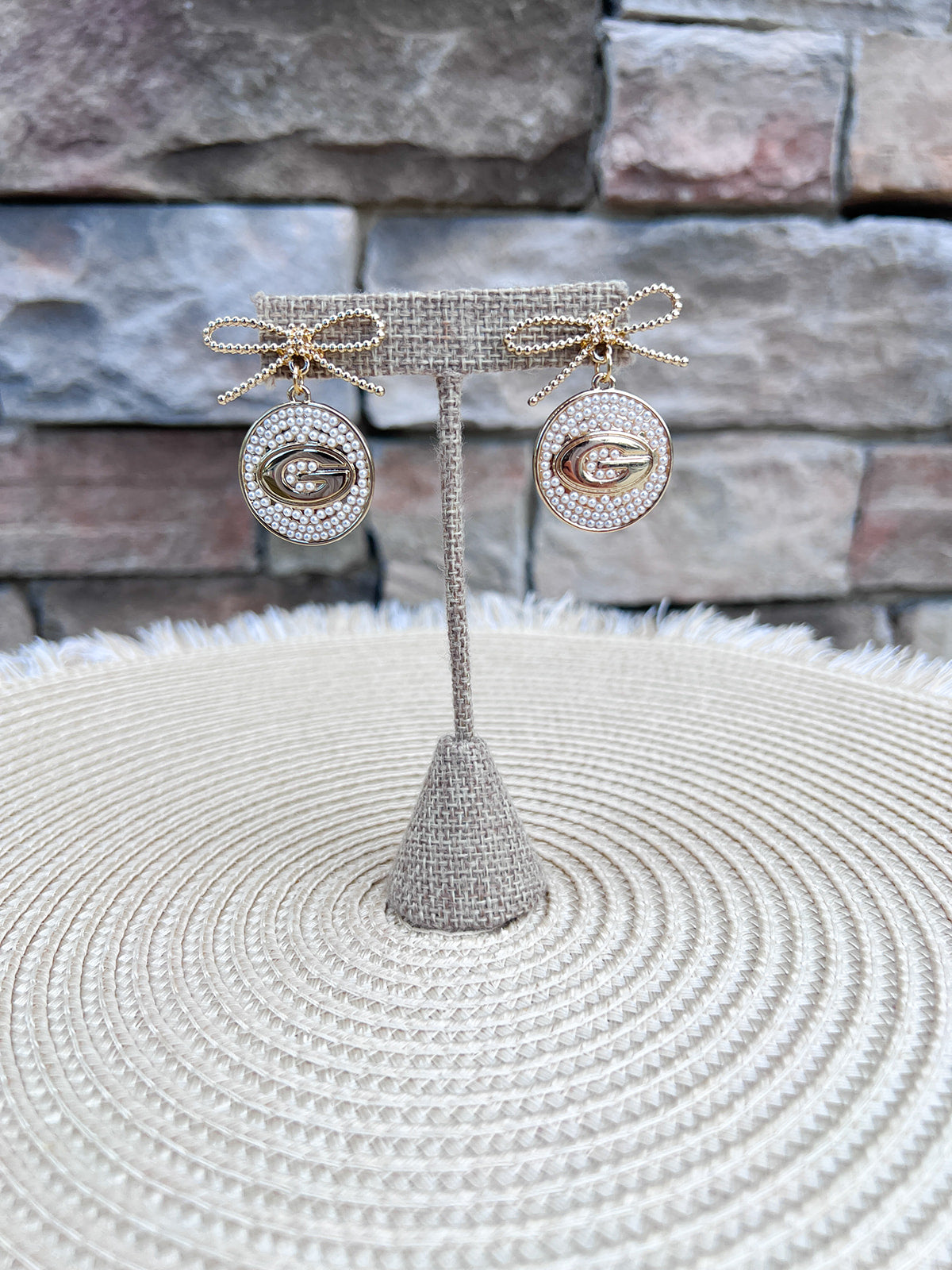 Georgia Bulldogs pearl and bow statement earrings featuring gold bows, pearl-accented medallions, and the Georgia Bulldogs logo.