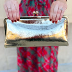 Gold Isabella Clutch featuring a sleek vegan leather design with clasp closure and structured silhouette.
