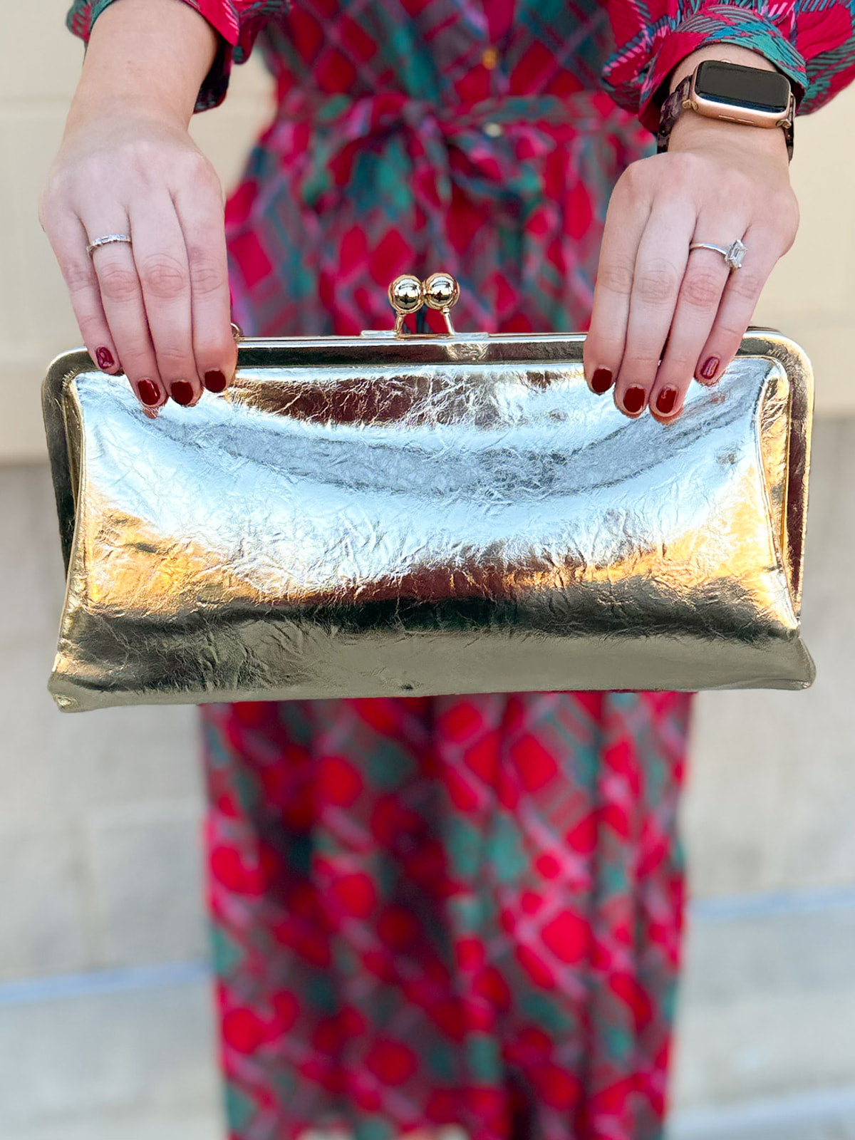 Gold Isabella Clutch featuring a sleek vegan leather design with clasp closure and structured silhouette.