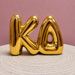 Gold Kappa Delta bubble letter shelf décor with a polished metallic finish.