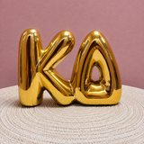 Gold Kappa Delta bubble letter shelf décor with a polished metallic finish.