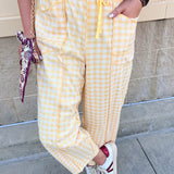 Golden yellow and white checkered pants with an elastic tie waistband and front pockets.