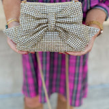 Gold gemstone crossbody bag with bow detail and metal chain strap.