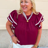 Garnet woven top with round neckline, ruffle sleeves, and flowy relaxed silhouette.