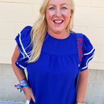 Royal blue woven top with round neckline, ruffle sleeves, and flowy relaxed silhouette.