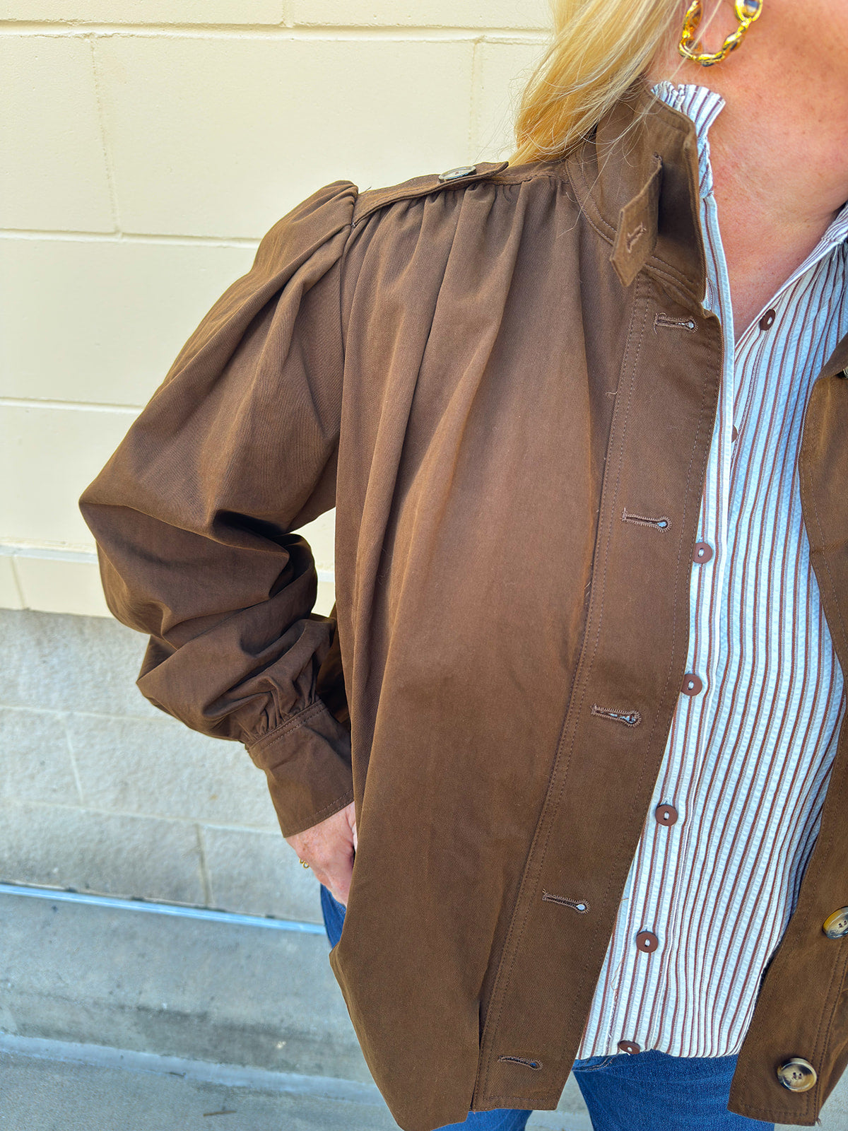 Hazelnut brown jacket with five front buttons, shoulder button accents, and a versatile high neckline