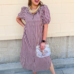 Dark red checkered midi dress with puff sleeves, a ruffled collar, button-down front, hidden side pockets, and a flowing midi-length silhouette.