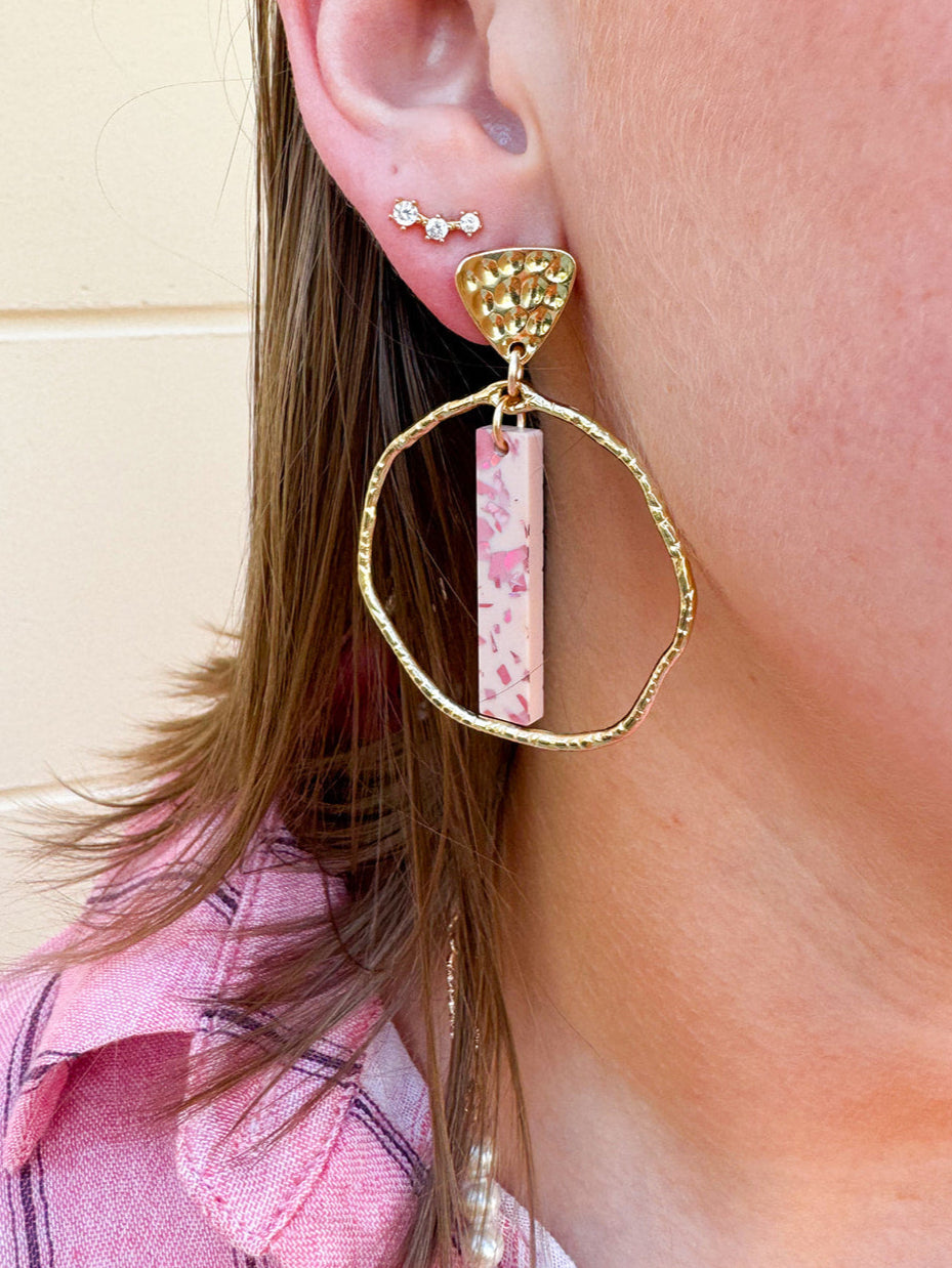 Hammered gold hoop earrings with pink acrylic stick flecked with darker pink, designed by Taylor Shaye.