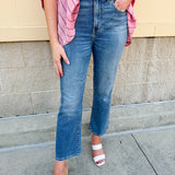 Light wash cropped flare jeans with raw edge hem, styled with a flattering high rise and vintage finish.