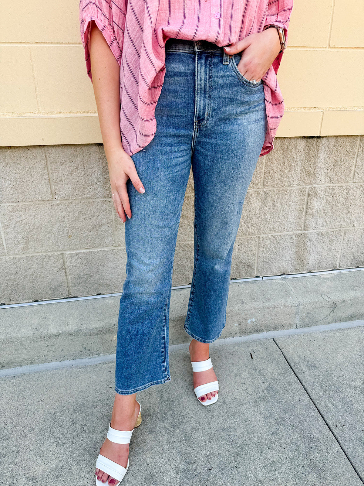 Light wash cropped flare jeans with raw edge hem, styled with a flattering high rise and vintage finish.