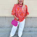 Pink and orange paisley print blouse with frilled tie neckline and three-quarter peasant sleeves against a neutral background