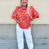 Pink and orange paisley print blouse with frilled tie neckline and three-quarter peasant sleeves against a neutral background