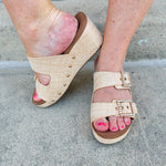 Raffia wedge sandal with slide-on design, dual straps, rhinestone buckles, and gold hardware embellishments