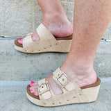 Raffia wedge sandal with slide-on design, dual straps, rhinestone buckles, and gold hardware embellishments