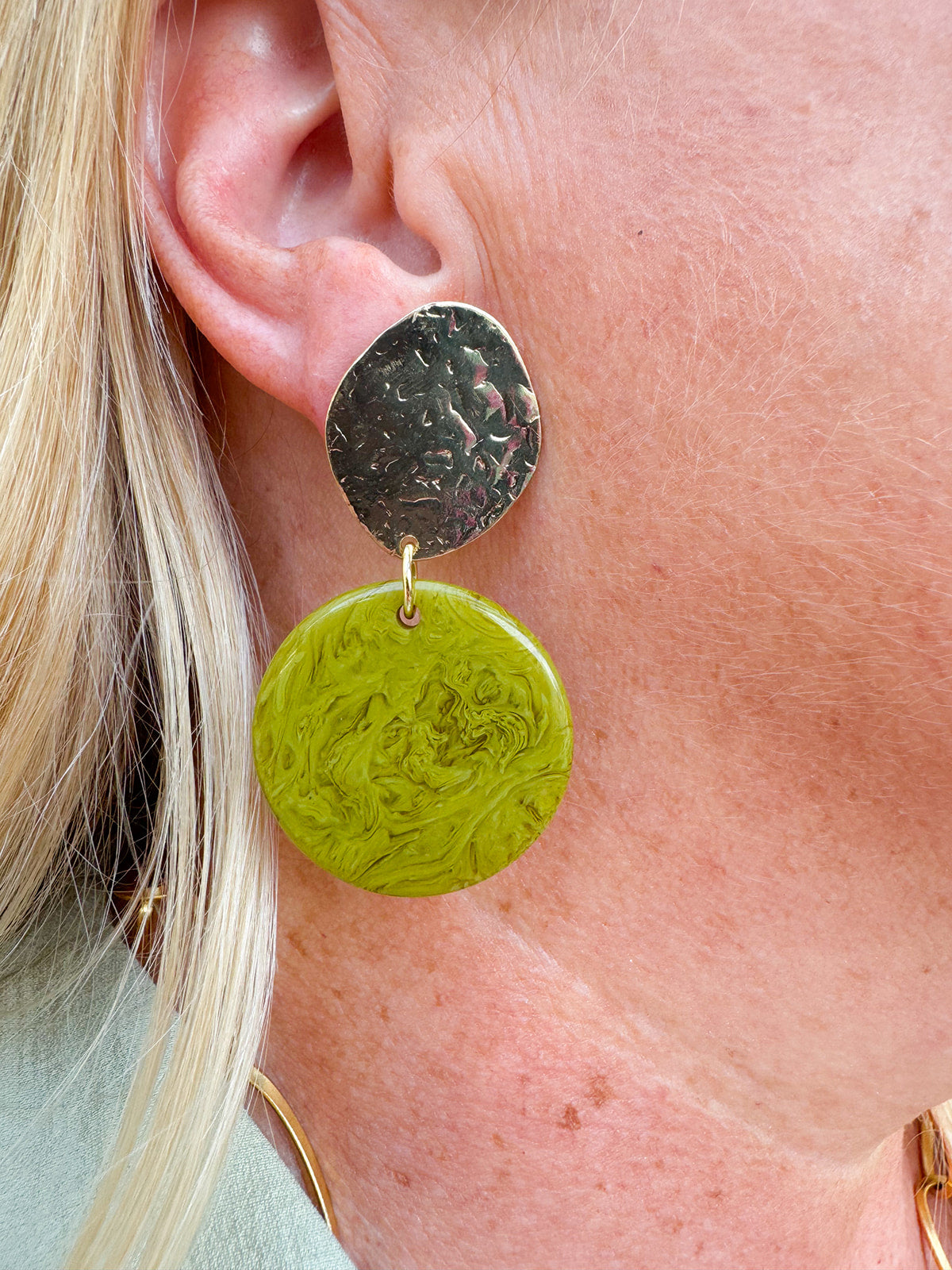 Statement earrings featuring a pistachio green base with gold accents, displayed on a neutral background for a pop of color