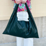 Green woven shoulder bag with soft structure and magnetic closure, designed for stylish and functional everyday use