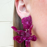 Oversized floral-shaped drop earrings in a pearlized dark red and purple color.