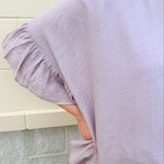Mauve ruffle duster cardigan with open front and ruffled detailing along sides and sleeves.