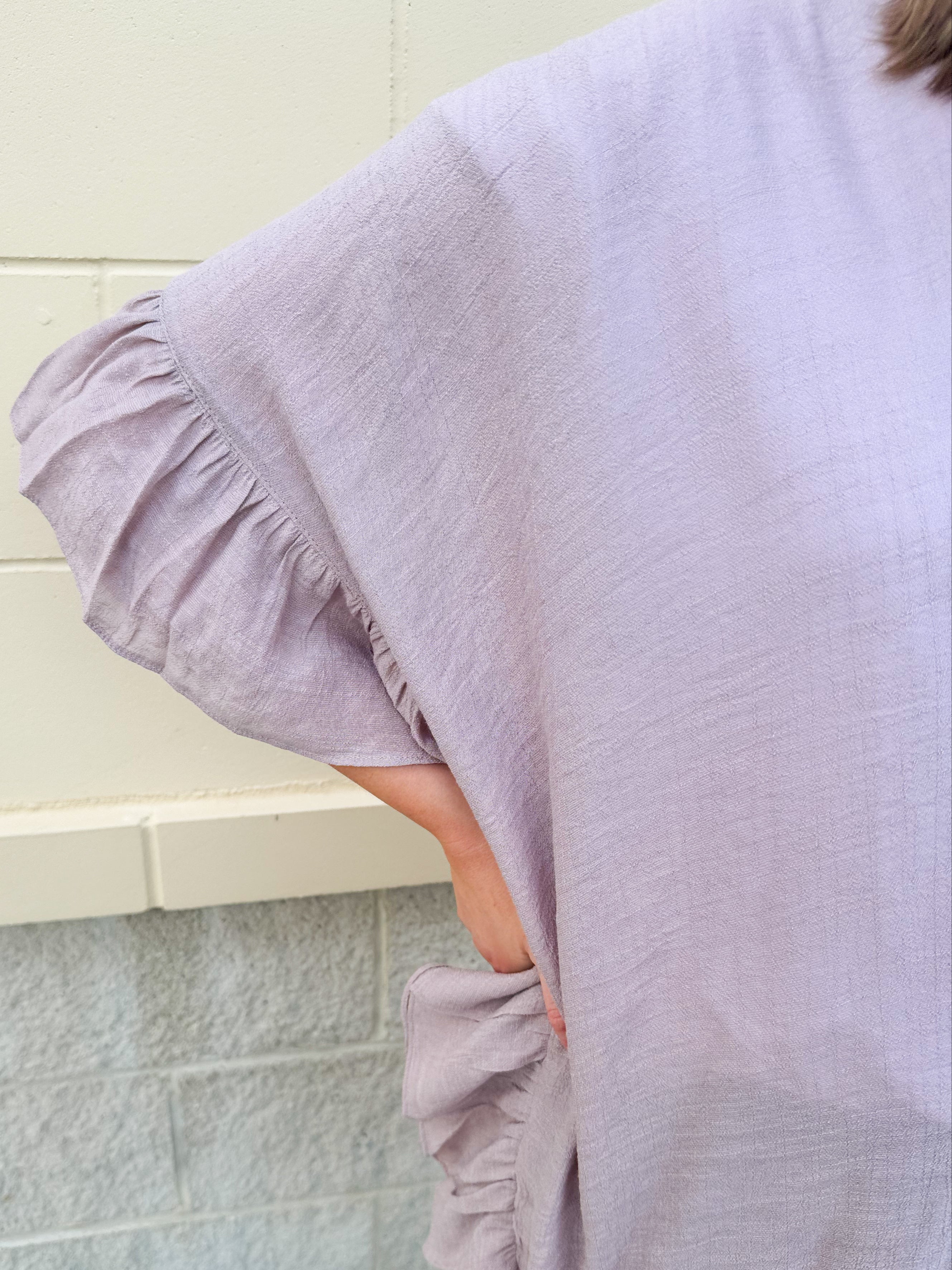 Mauve ruffle duster cardigan with open front and ruffled detailing along sides and sleeves.