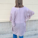 Mauve ruffle duster cardigan with open front and ruffled detailing along sides and sleeves.