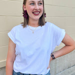 White rolled sleeve tee displayed on hanger or model, showing relaxed fit and classic style.