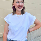 White rolled sleeve tee displayed on hanger or model, showing relaxed fit and classic style.