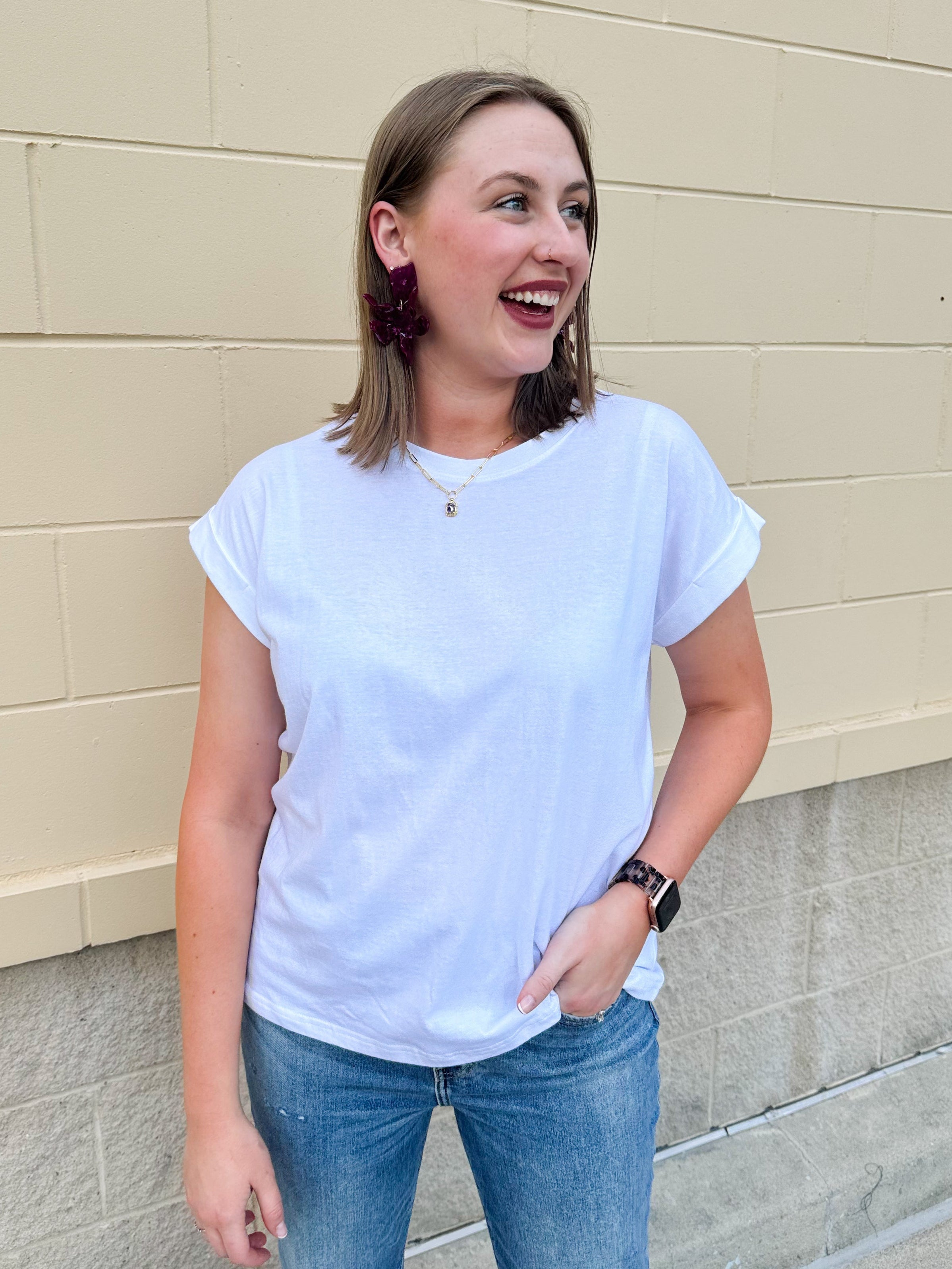 White rolled sleeve tee displayed on hanger or model, showing relaxed fit and classic style.