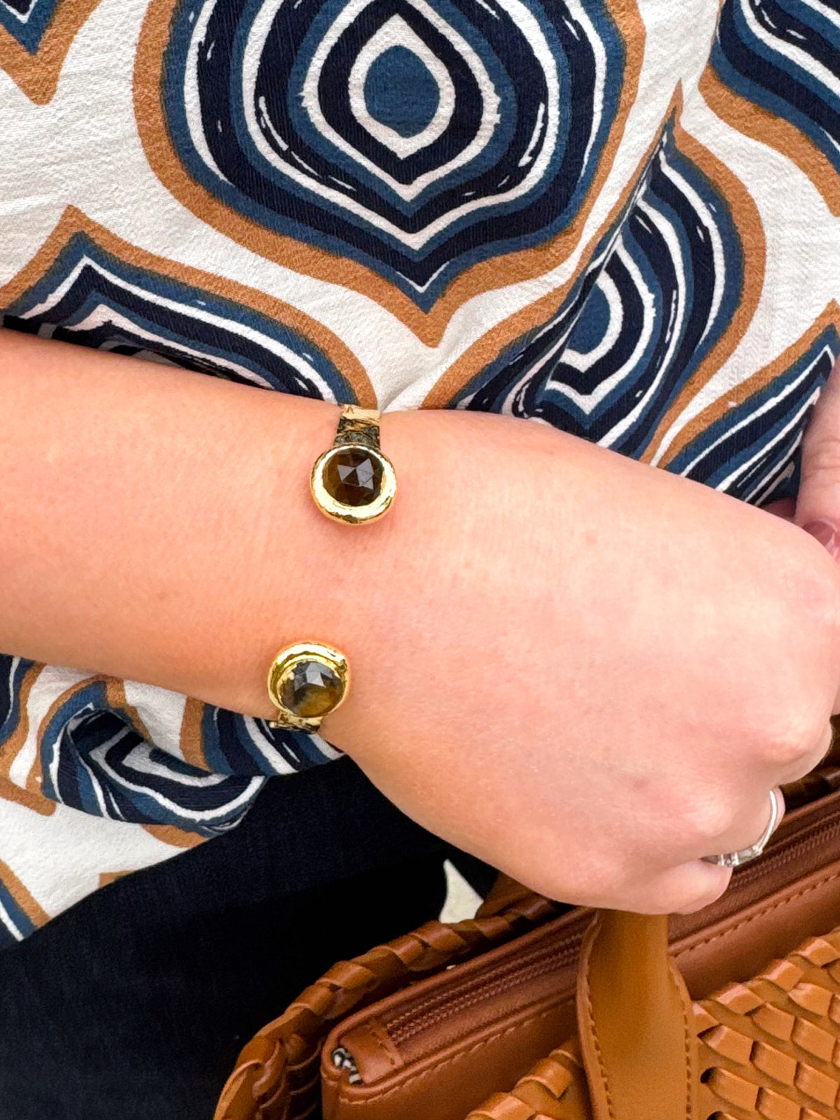 Gold cuff with two round tigers eye stones.