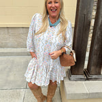 White floral mini dress with ¾ sleeves and colorful pink, orange, green, and blue print