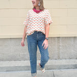 Bright floral v-neck top with dolman sleeves and drop shoulder design, styled for a relaxed and feminine look.