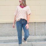 Bright floral v-neck top with dolman sleeves and drop shoulder design, styled for a relaxed and feminine look.