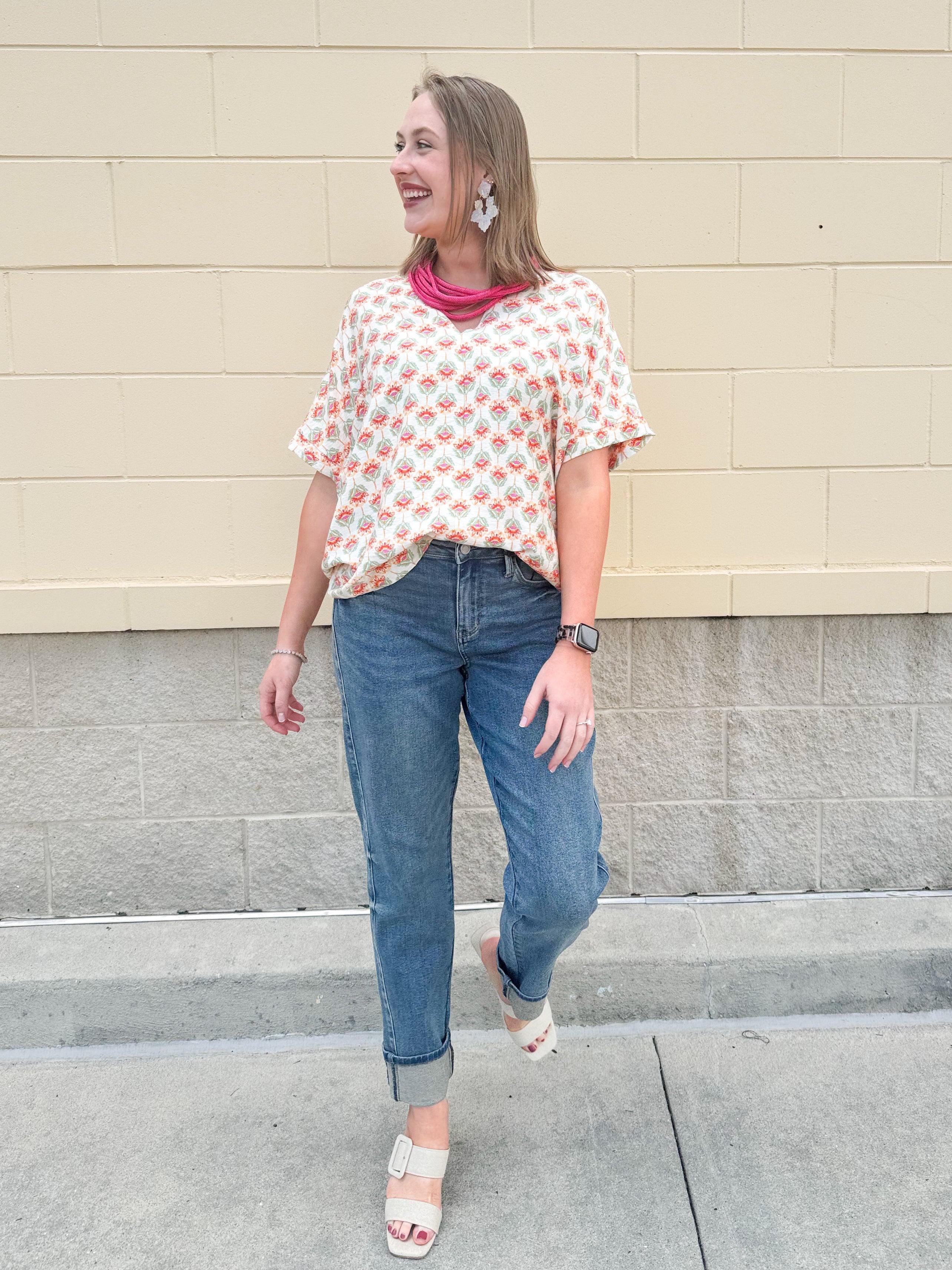 Bright floral v-neck top with dolman sleeves and drop shoulder design, styled for a relaxed and feminine look.