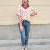 Bright floral v-neck top with dolman sleeves and drop shoulder design, styled for a relaxed and feminine look.