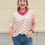 Bright floral v-neck top with dolman sleeves and drop shoulder design, styled for a relaxed and feminine look.
