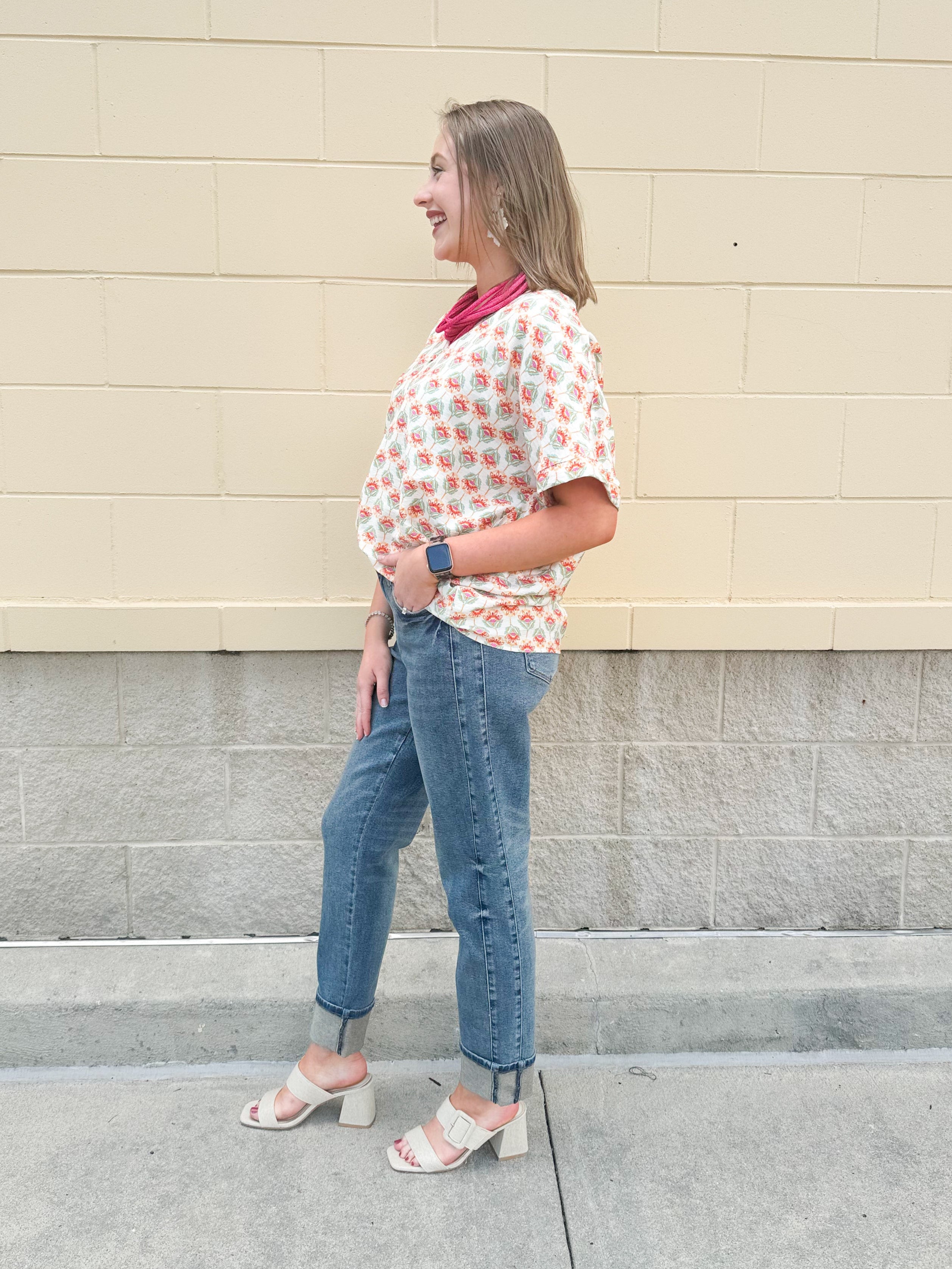 Bright floral v-neck top with dolman sleeves and drop shoulder design, styled for a relaxed and feminine look.