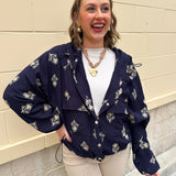 Navy embroidered long sleeve Jacket top with hood, cinched waist, and front pockets styled for fall.