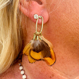 Quail feather tassel statement earrings with speckled feathers and soft tassels, displayed on a neutral background