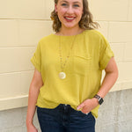 Mustard oversized ribbed top with front pocket, drop shoulders, and raw frayed hemline