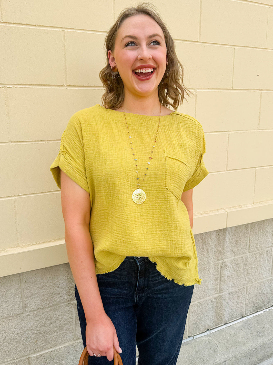 Mustard oversized ribbed top with front pocket, drop shoulders, and raw frayed hemline