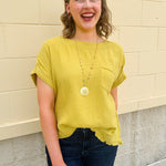 Mustard oversized ribbed top with front pocket, drop shoulders, and raw frayed hemline