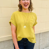 Mustard oversized ribbed top with front pocket, drop shoulders, and raw frayed hemline