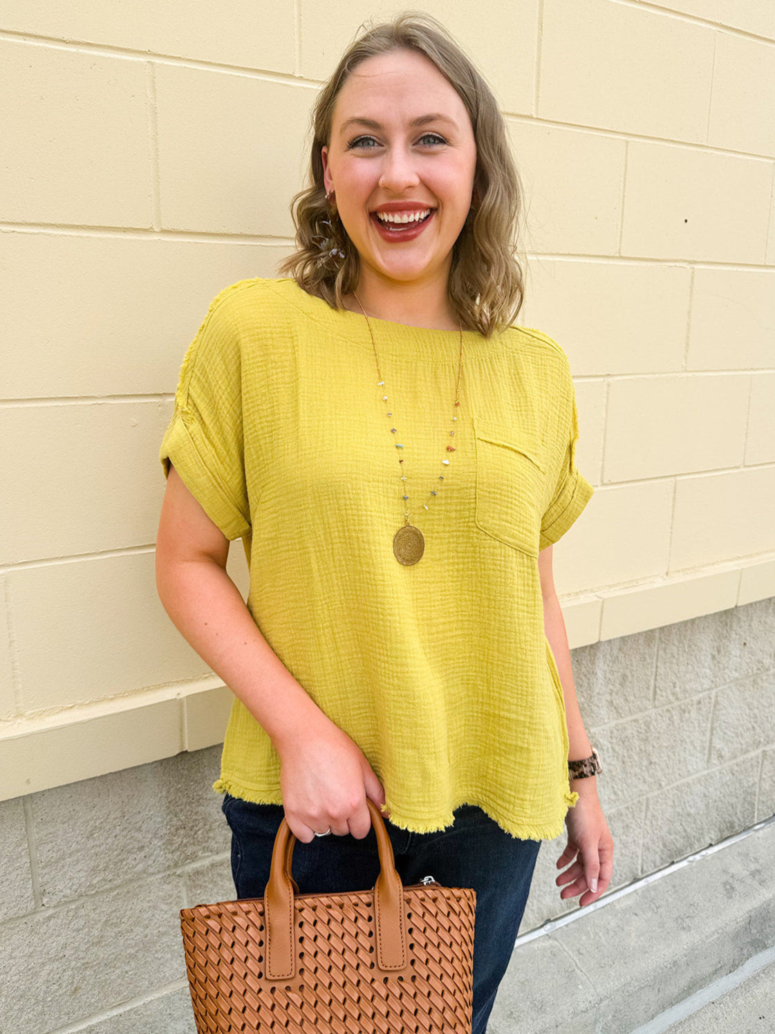 Mustard oversized ribbed top with front pocket, drop shoulders, and raw frayed hemline