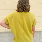 Mustard oversized ribbed top with front pocket, drop shoulders, and raw frayed hemline