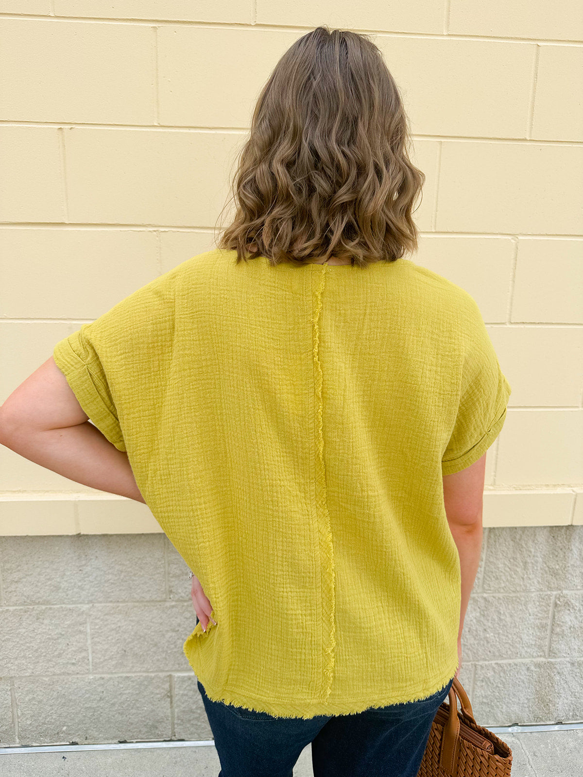 Mustard oversized ribbed top with front pocket, drop shoulders, and raw frayed hemline