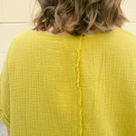 Mustard oversized ribbed top with front pocket, drop shoulders, and raw frayed hemline