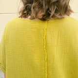 Mustard oversized ribbed top with front pocket, drop shoulders, and raw frayed hemline