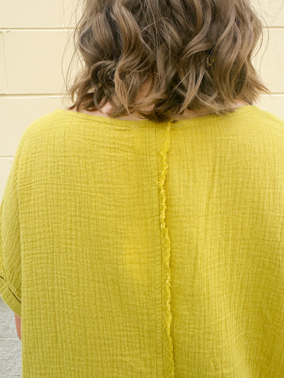 Mustard oversized ribbed top with front pocket, drop shoulders, and raw frayed hemline