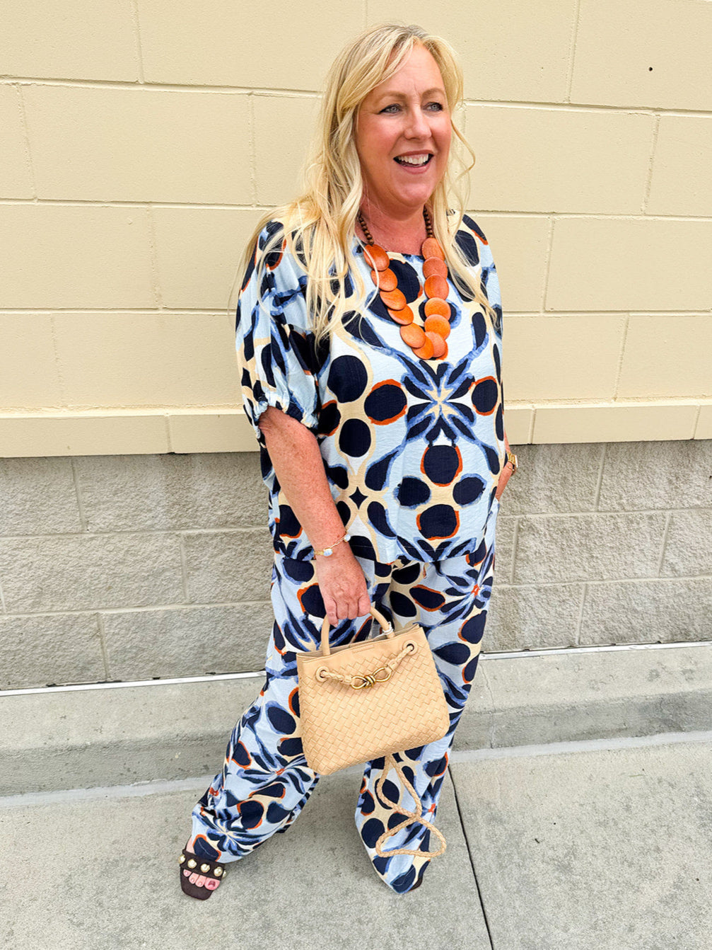 Printed short sleeve top in light blue with colorful indigo, orange, and yellow pattern, featuring a boat neck and relaxed A-line shape