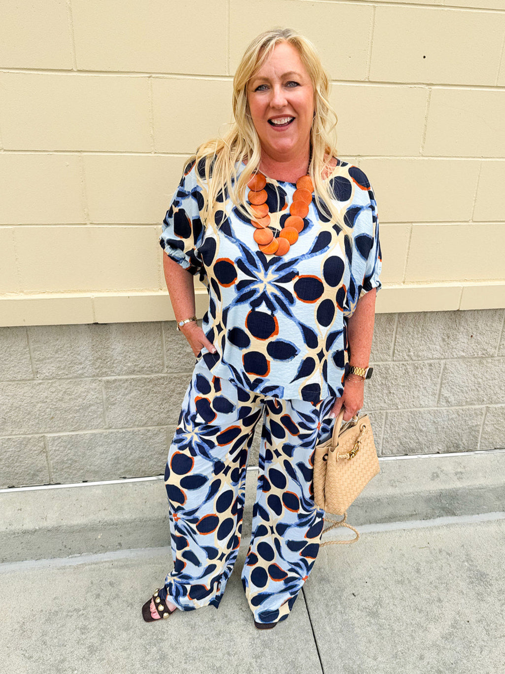 Printed short sleeve top in light blue with colorful indigo, orange, and yellow pattern, featuring a boat neck and relaxed A-line shape